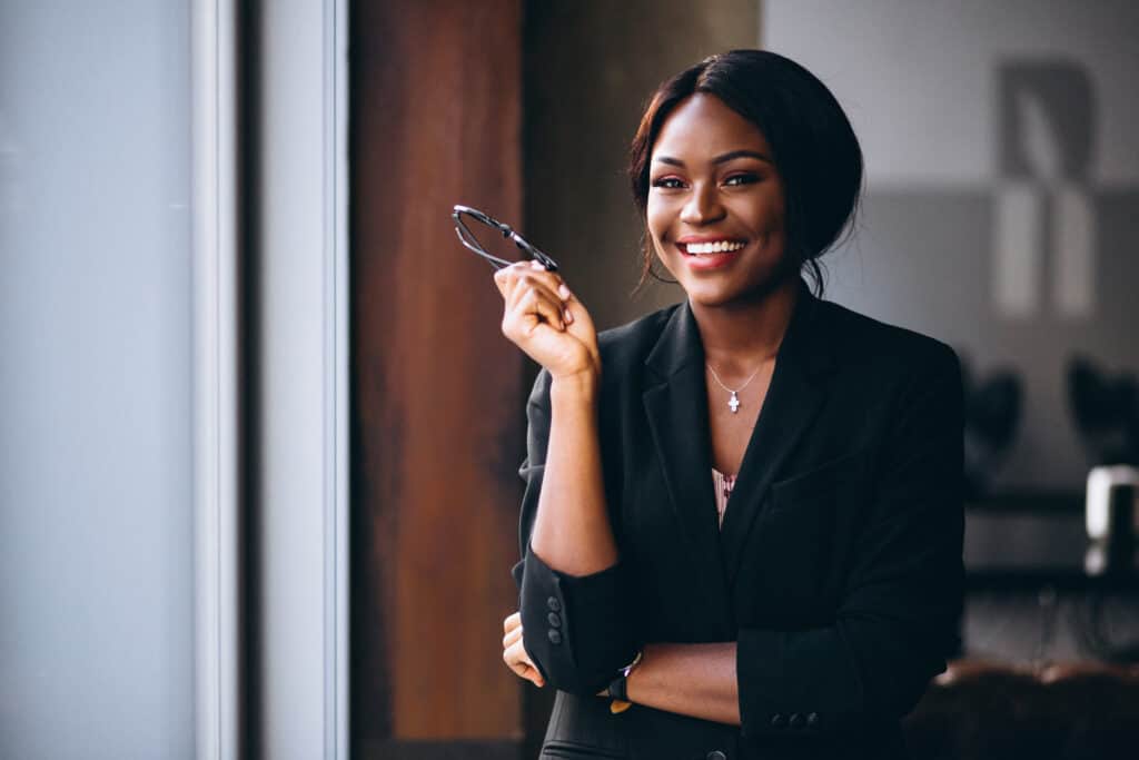 African American business woman smiling after reviewing her minority small business grants applications..
