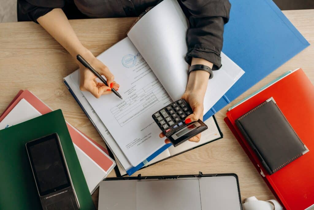 Person with red nail polish reviews financial documents